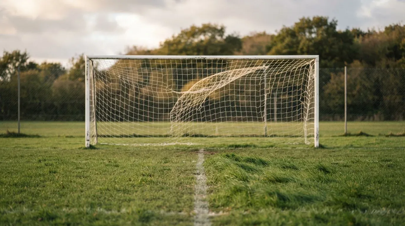 Ein Fussballtor mit locker hängendem Netz auf einem Trainingsplatz, das sich leicht im Wind bewegt.