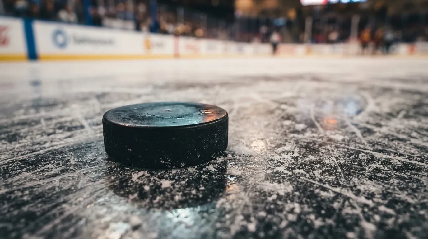 Ein Eishockeypuck liegt auf einer Eisfläche mit Kratzspuren, Nahaufnahme mit kühlen Reflexen